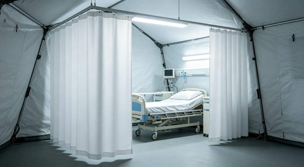 Privacy partition inside inflatable medical tent, fabric curtain separating patient areas red and white inflatable emergency shelter for disaster relief operations