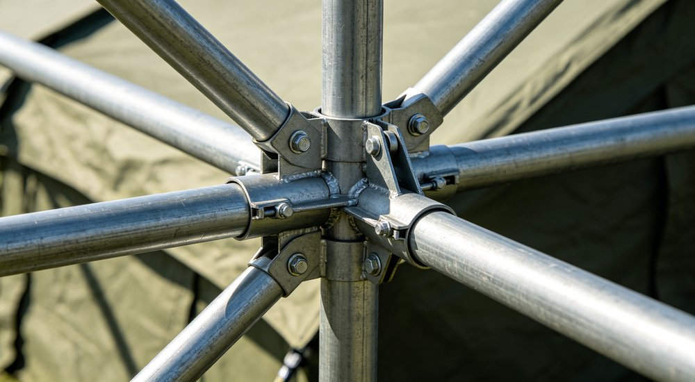 Metal frame tent poles and joints laid out, steel tubing, product shot red and white inflatable emergency shelter for disaster relief operations