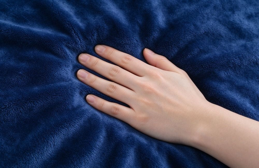 Close-up of flannel blanket fabric texture showing weave and pile on a bright surface, showing relief blanket material quality and specification